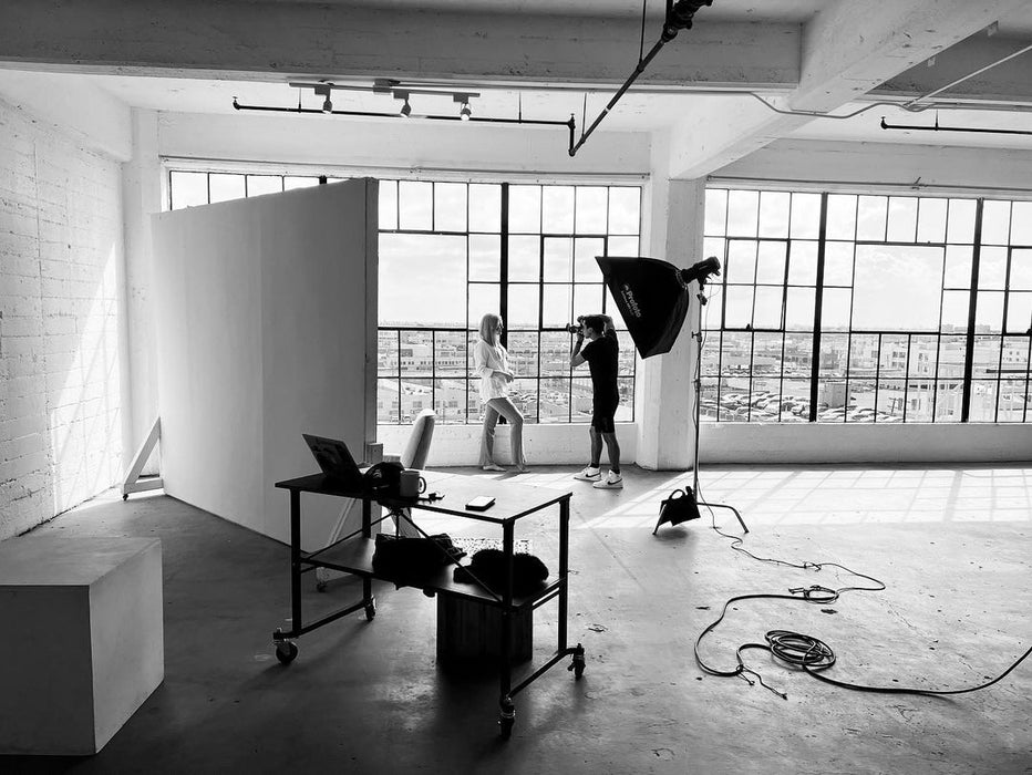 Behind the scenes of a professional photoshoot at Sunrise Studio, Apex Photo Studios' Studio D with cityscape view