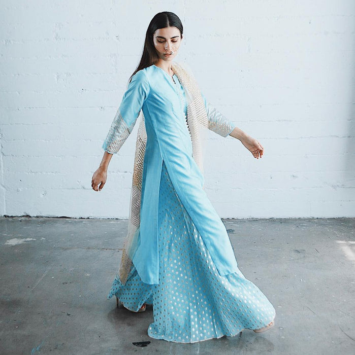 Model in elegant traditional blue attire with gold accents gracefully moving at Sunrise Studio, Apex Photo Studios' Studio D