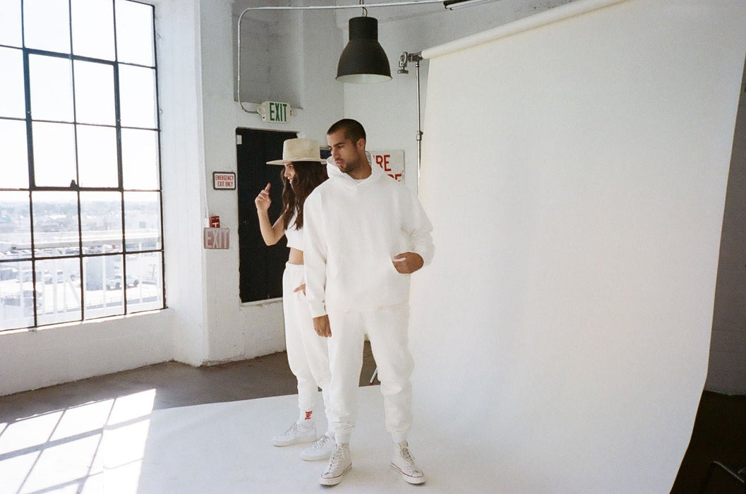 Stylish couple in coordinated white outfits during a creative photoshoot at Sunrise Studio, Apex Photo Studios' Studio D