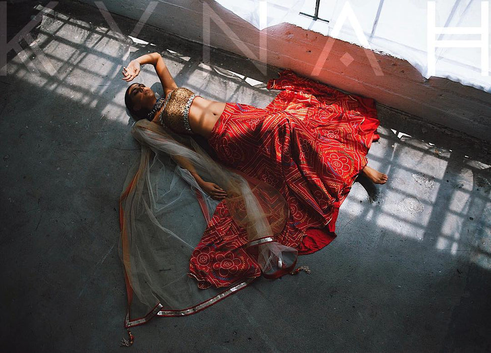 Fashion model in traditional attire lying on the floor at Sunrise Studio, part of Apex Photo Studios in Studio D with dramatic lighting and elegant poses