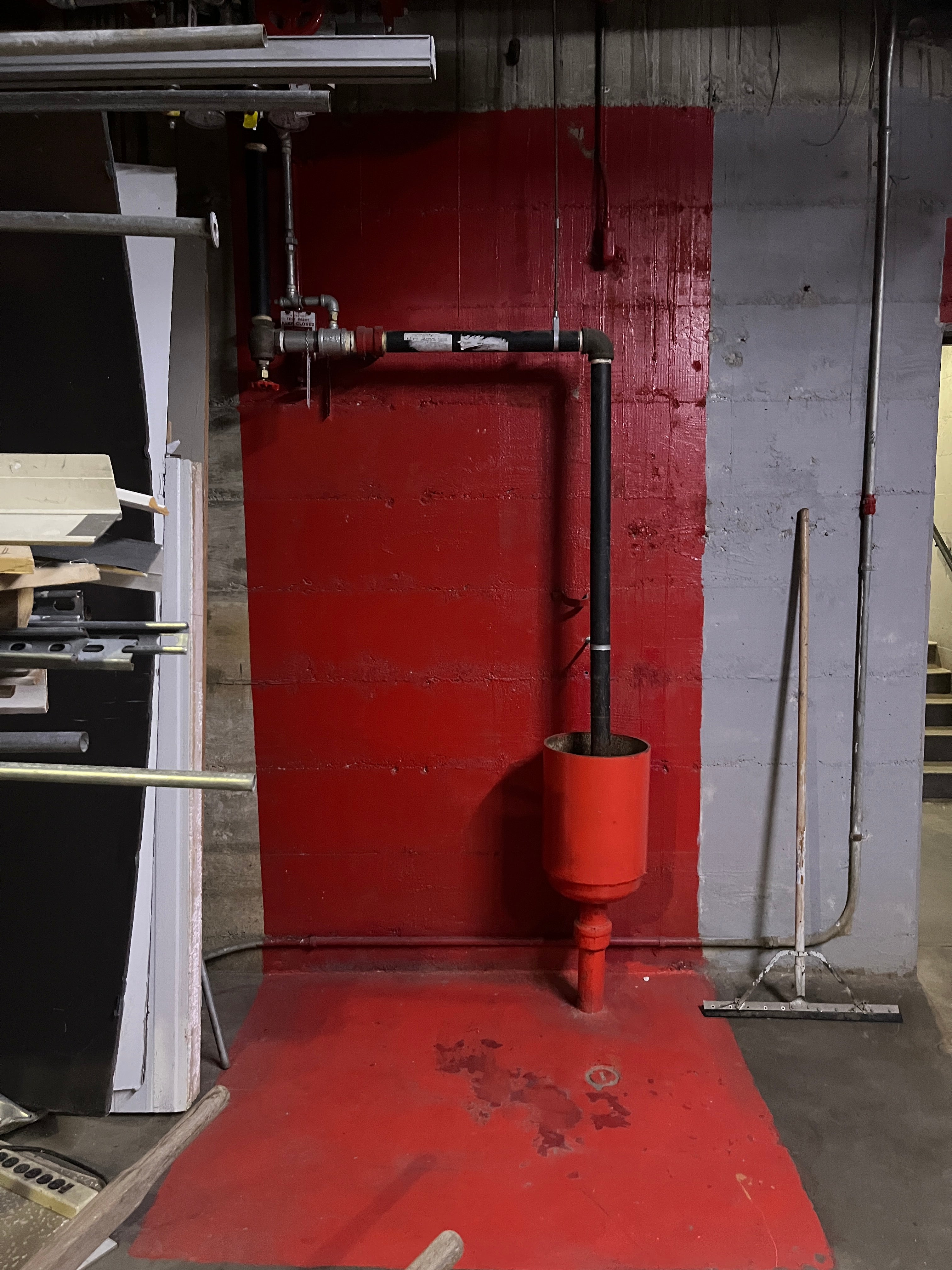 Red industrial machine with pipes and a valve on a gray background